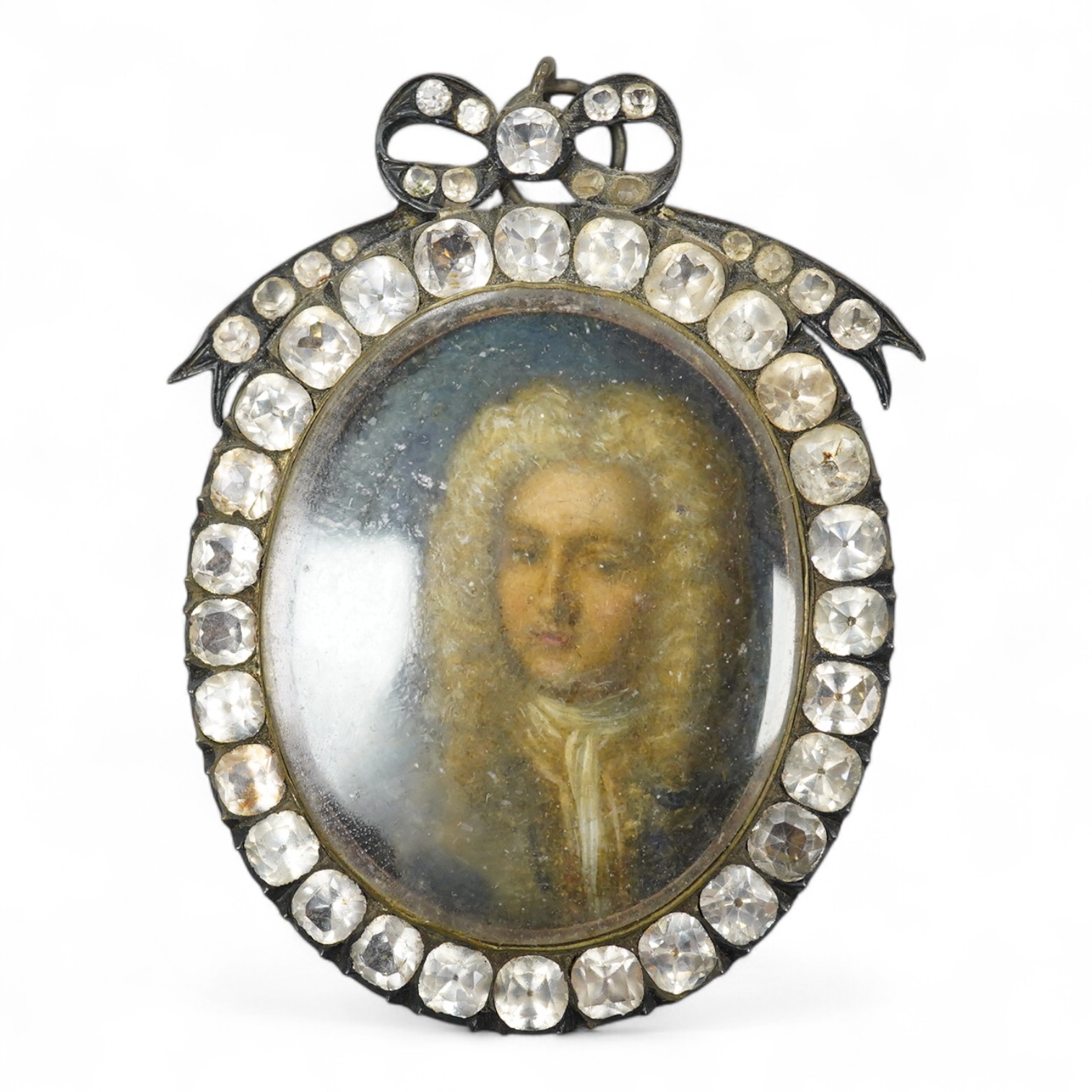 18th century, English School, Portrait of a young man wearing a wig, oil on copper, housed in an ornate jewelled frame, overall 8cm high